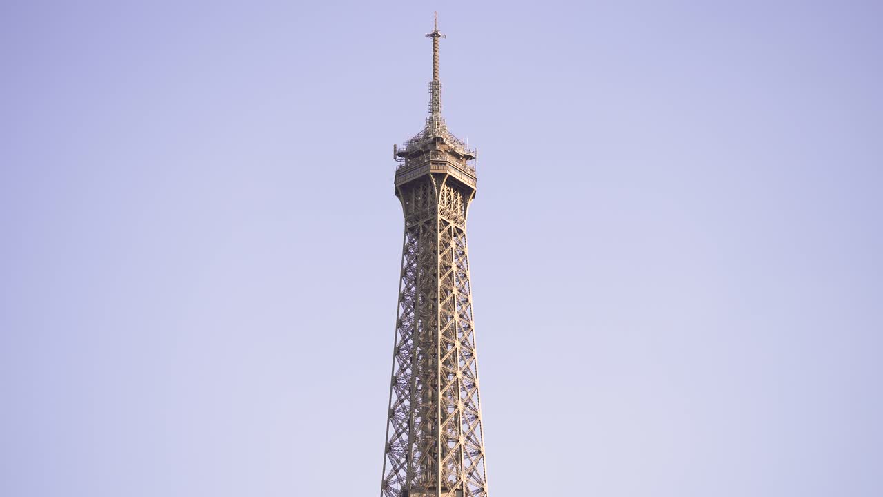 la parte superior de la torre eiffel vista durante el día desde el río sena, mirando hacia arriba desde un bote