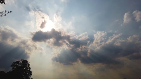 cumulus clouds covering the sun causing strong shadows and light rays, tyndall effect.