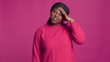 black woman in sweater having headache