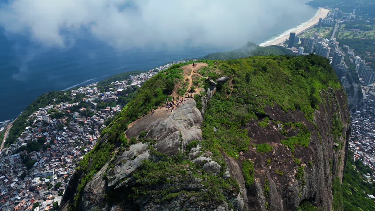 Panorama-droneoptagelse, der kredser om mennesker på Dois Irmãos-bjerget i Rio, Brasilien