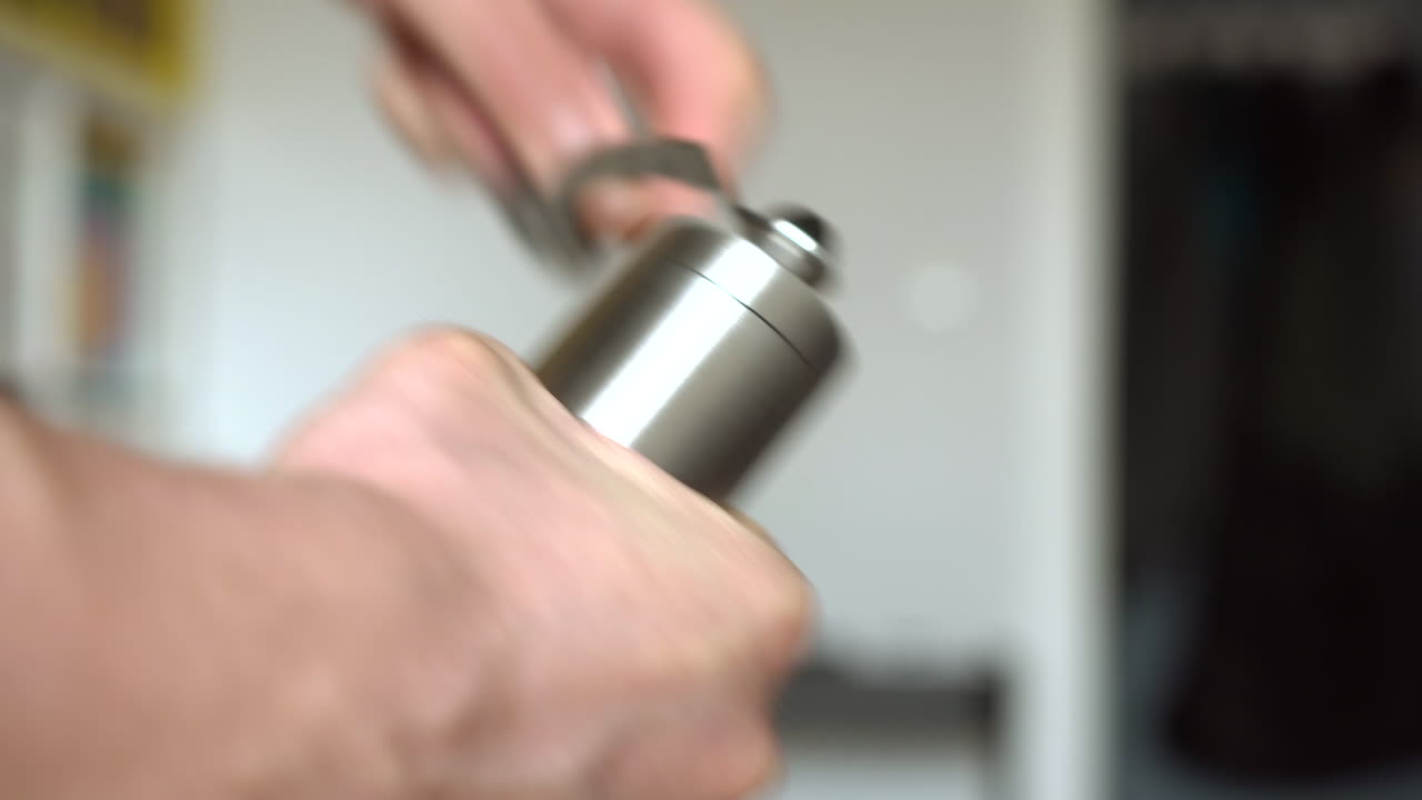 el hombre está moliendo granos de café a mano.