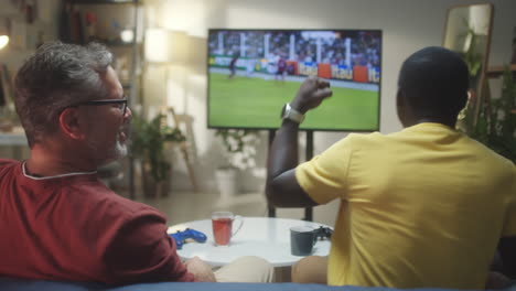 men watching and celebrating a soccer match at home