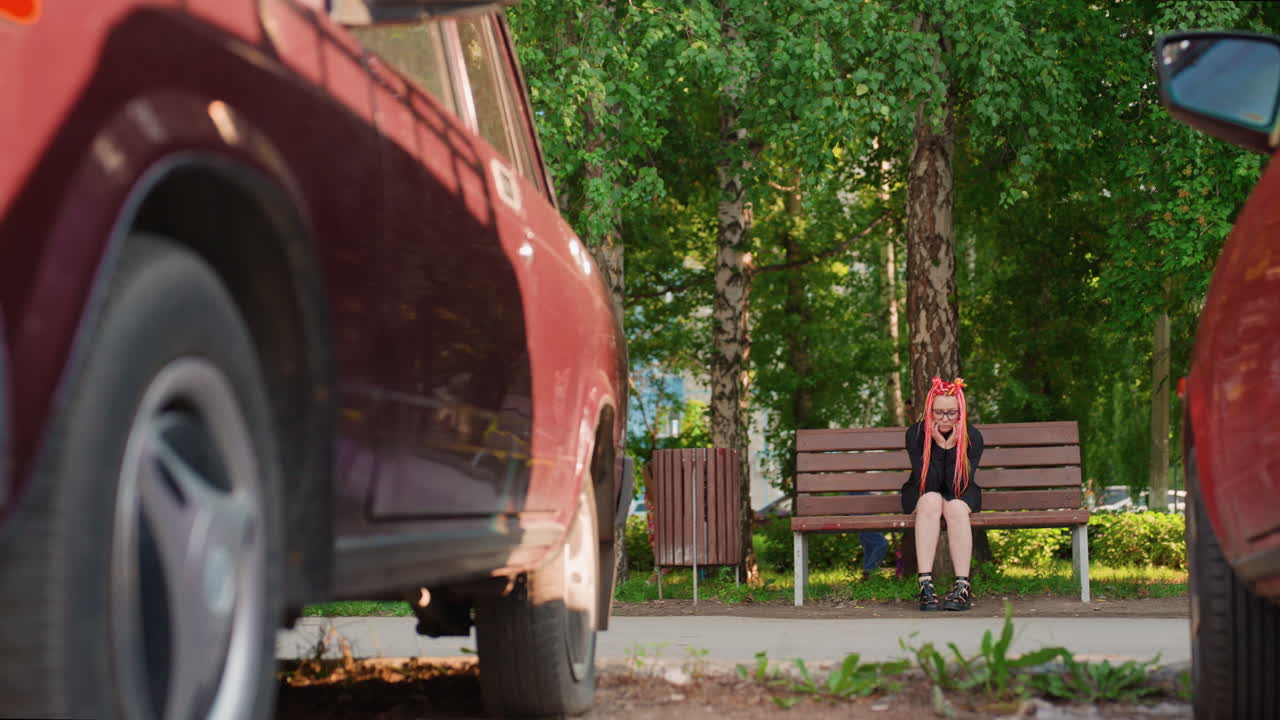 낮은 시점에서 자동차 바퀴가 지나가는 모습, 벤치에 앉아 있는 백인 스케이터, 프레임 가까이에서 타이어가 회전, 모션 블러와 갑작스러운 긴장감, 배경에 벤치와 자작나무, 깜짝 놀라는 반응과 도시의 위험 요소