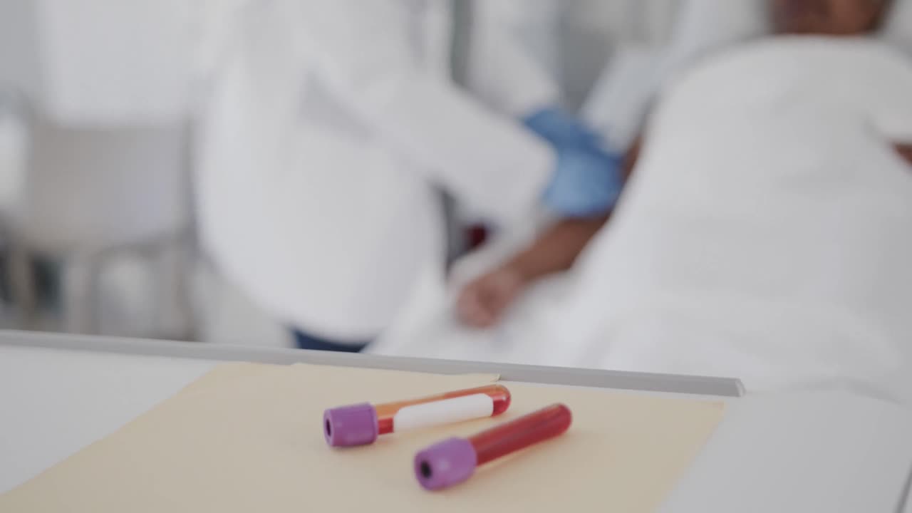 Blood samples and diverse female doctor talking with senior patient in bed, slow motion