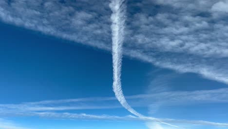 Aerial-view-from-a-jet-cockpit-of-a-blue-sky-with-a-lot-of-jet-wakes