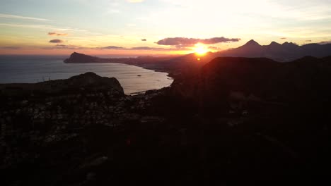 beautiful sunset between coastline and mountains in the spanish province of alicante near the city calp