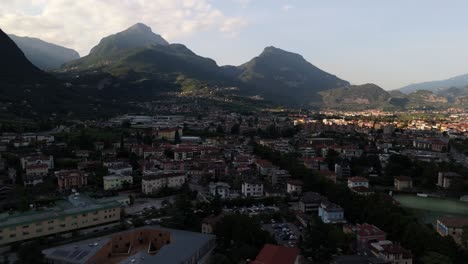 drone footage of a picturesque italian town nestled below majestic mountains, highlighting the blend of historic architecture and stunning natural scenery
