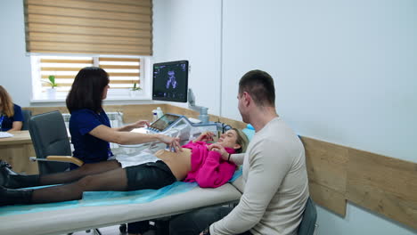 married couple at doctor's reception. woman is checked on the ultrasound machine. pregnancy examination at clinics.