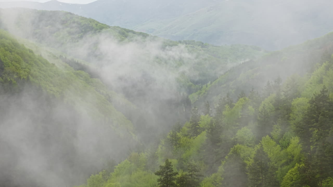 Moody landscape of rolling hills and forests blanketed in fog and early morning mist. Captured in spring near Koprivshtitsa, this tranquil aerial scene evokes calm and natural harmony.