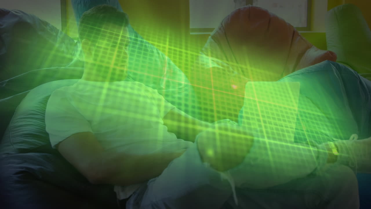 집에서 콩 가방에 앉아 노트북을 사용하는 백인 남자에 대한 반 ⁇ 이는 초록색 심박수 모니터