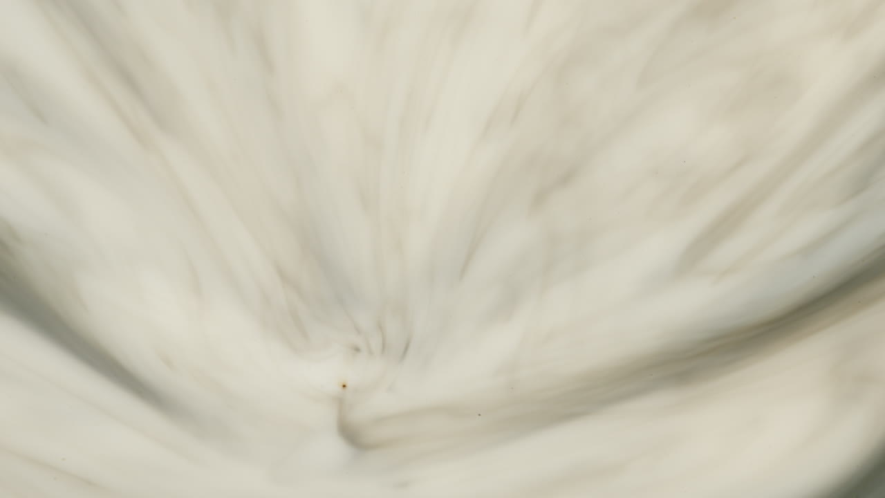 expansión fluida de la tinta gris en el fluido blanco.