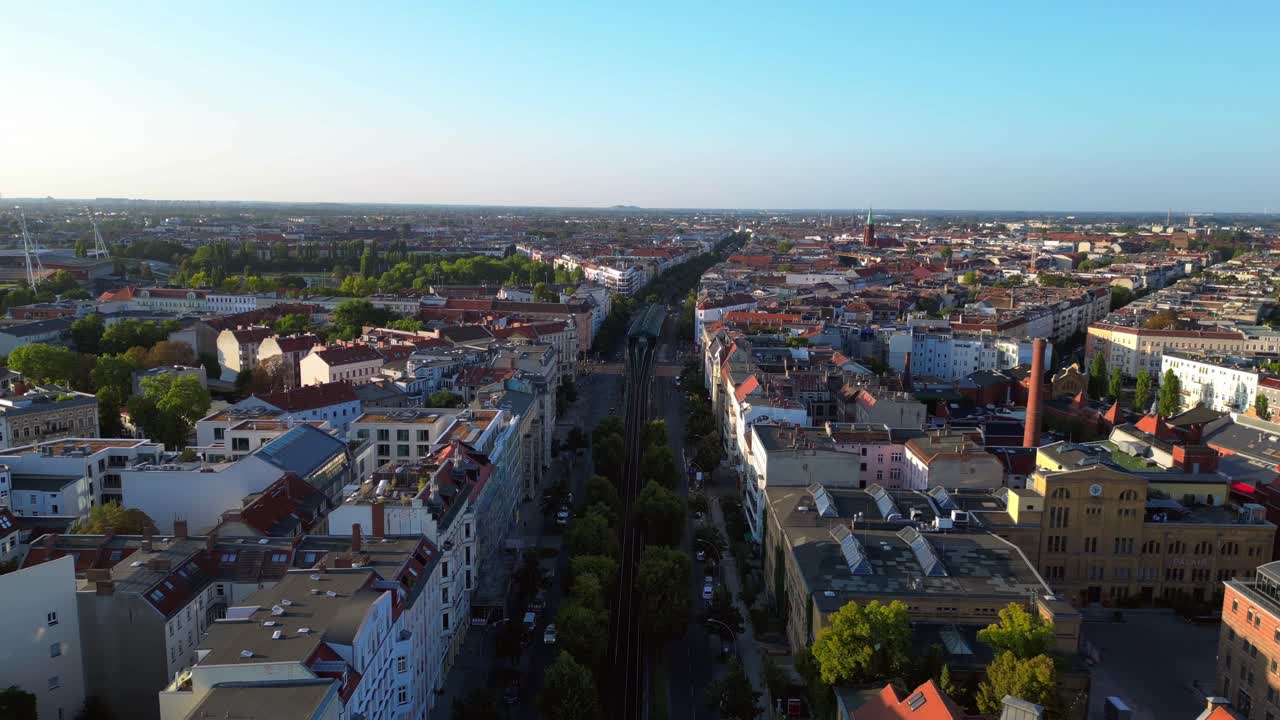 Elevated train navigating through a residential area in berlin, showcasing the city's urban transportation system. Smooth aerial view flight descending drone