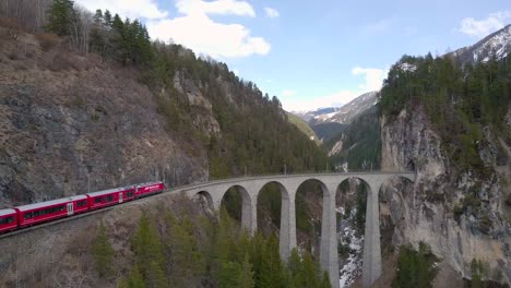 Aerial-view-of-the-famous-Bernina-Train-coming-out-the-mountain-tunnel