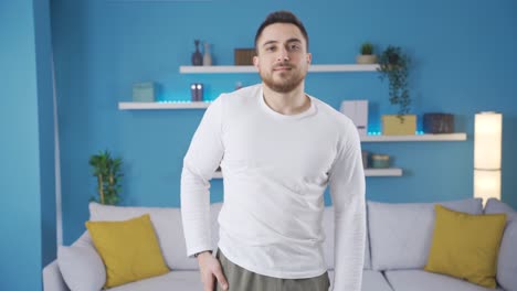 fitness trainer young man doing fitness exercises on mat in living room at home.