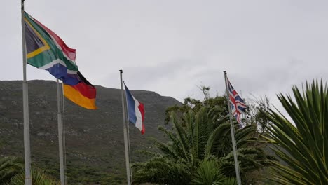 Banderas-De-Sudáfrica,-Alemania,-Francia-Y-Gran-Bretaña-Ondeando-Con-Fuertes-Vientos-En-Cape-Point,-Sudáfrica