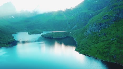 panning, crane down drone shot of surrounding rocky hills over lake ågvatnet in lofoten