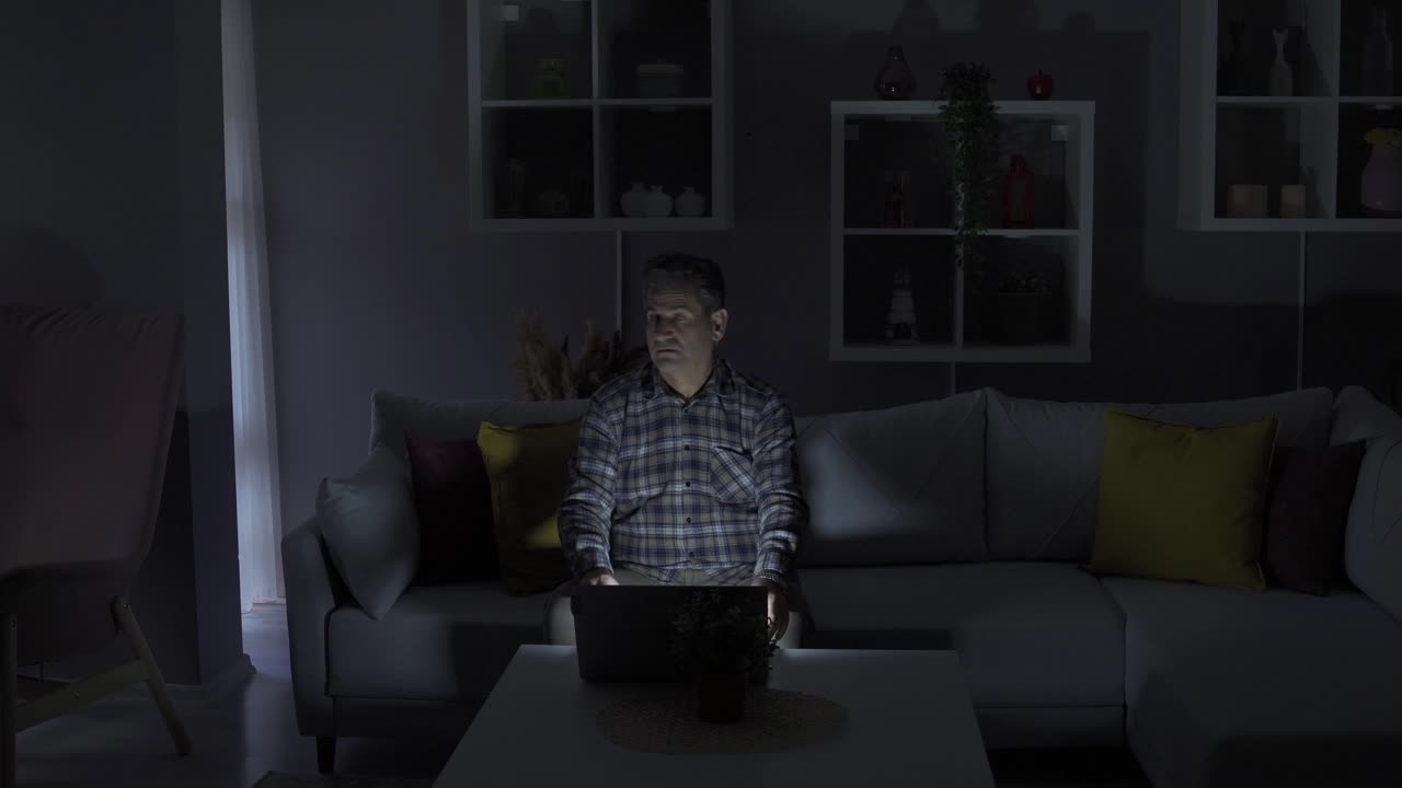 hombre que trabaja desde casa está teniendo un corte de energía. portátil, pero la electricidad se apaga y su trabajo se interrumpe.