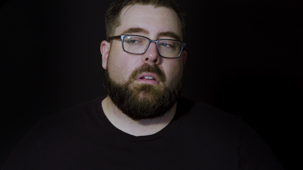 retrato de estudio de movimiento de un hombre barbudo que expresa aburrimiento y molestia