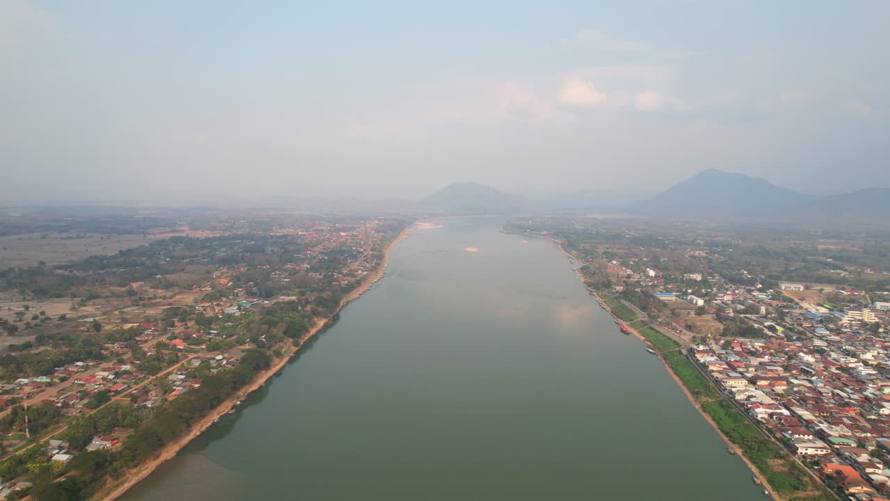 hermoso paisaje del río mekong en una mañana brumosa en el distrito de chiang khan en tailandia, vista aérea de un dron volando hacia atrás