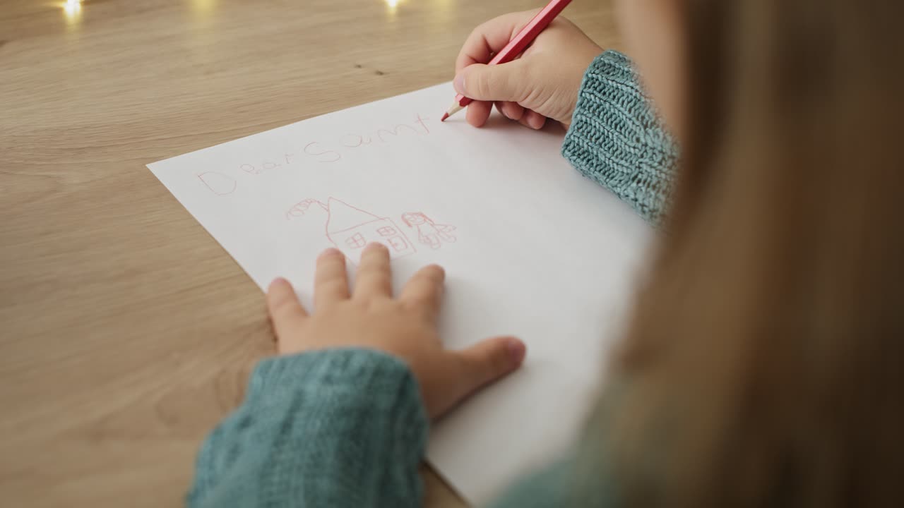 видео с высоким углом зрения маленького мальчика, пишущего письмо санта-клаусу