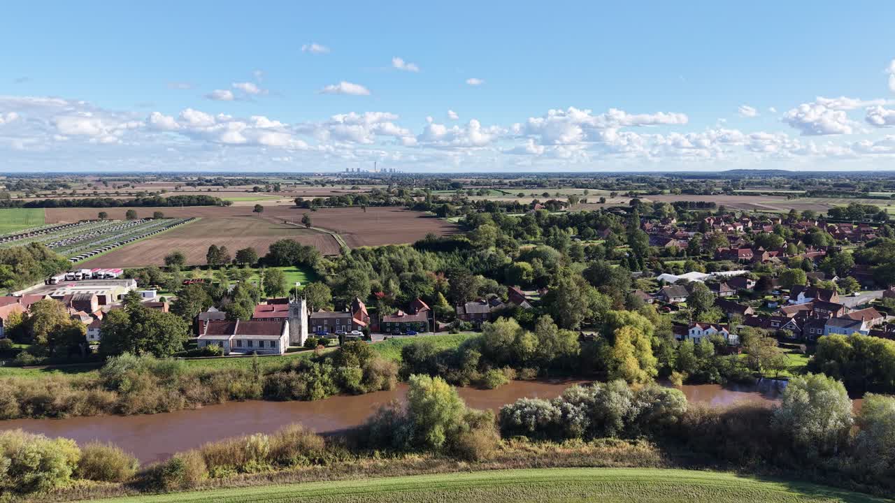 Luchtdronebeelden van landelijke buitenwijken nabij de Chiltern Hills in Buckinghamshire en Oxfordshire, Engeland, met dorpshuizen, een rivier, landbouwgrond, bomen en platteland.
