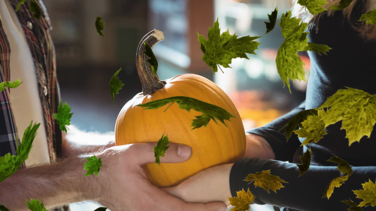 Animation of autumn leaves falling over couple holding pumkin
