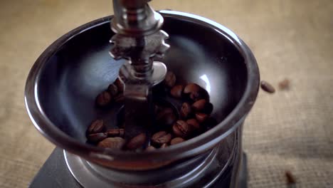 Coffee-beans-fall-in-the-old-grinder.-Slow-motion-with-rotation-tracking-shot.