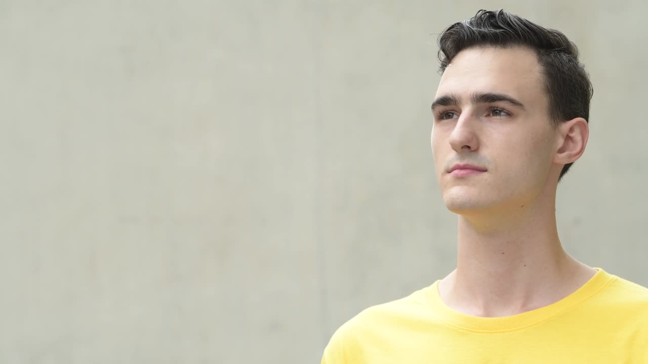 행복한 젊은 잘생긴 남자가 생각하면서 미소 짓고