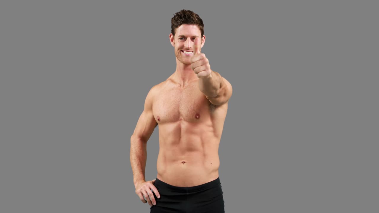 hombre musculoso con los pulgares hacia arriba posando