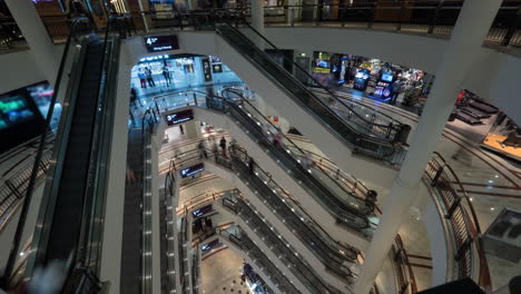 timelapse of people on escalators in multistorey shopping mall