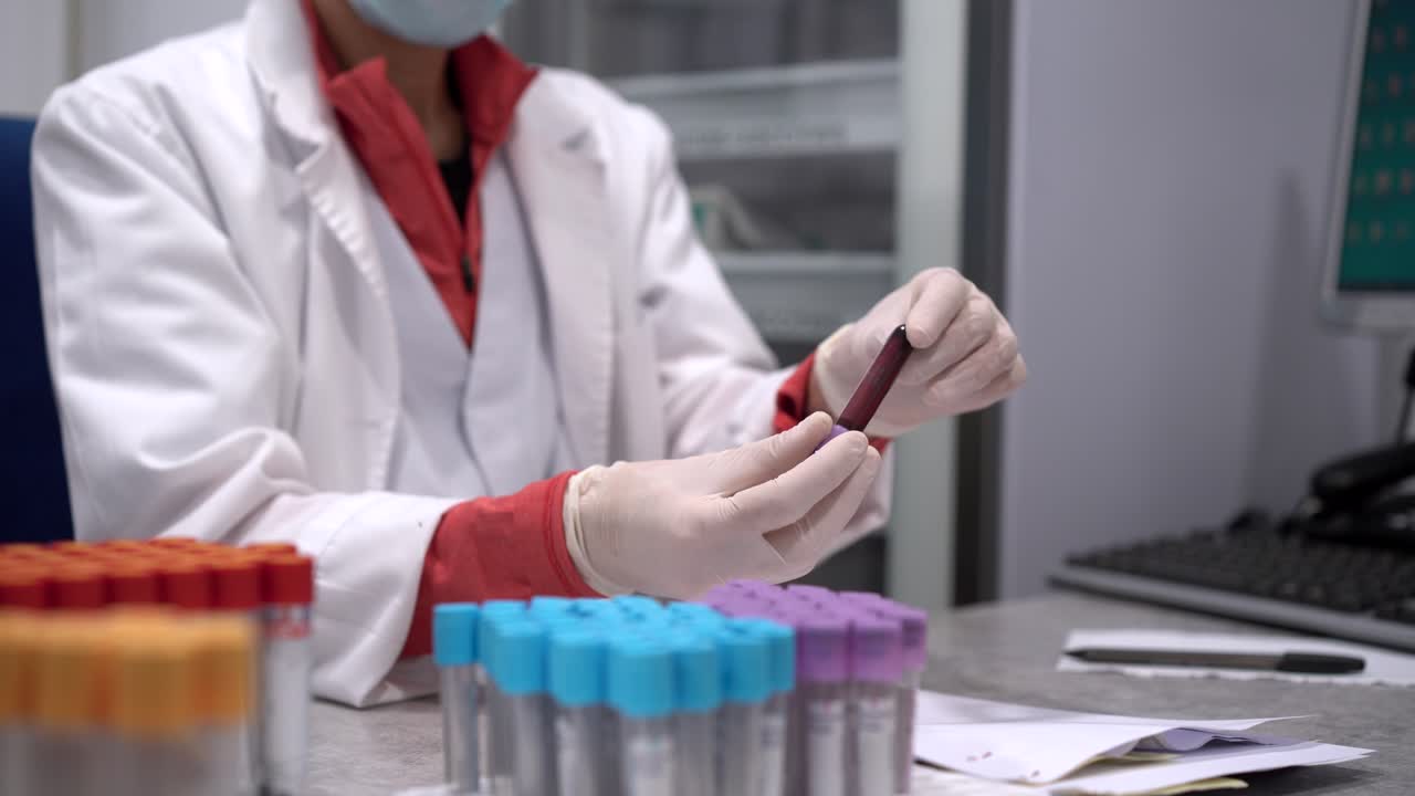 Female doctor with blood test in tube in laboratory