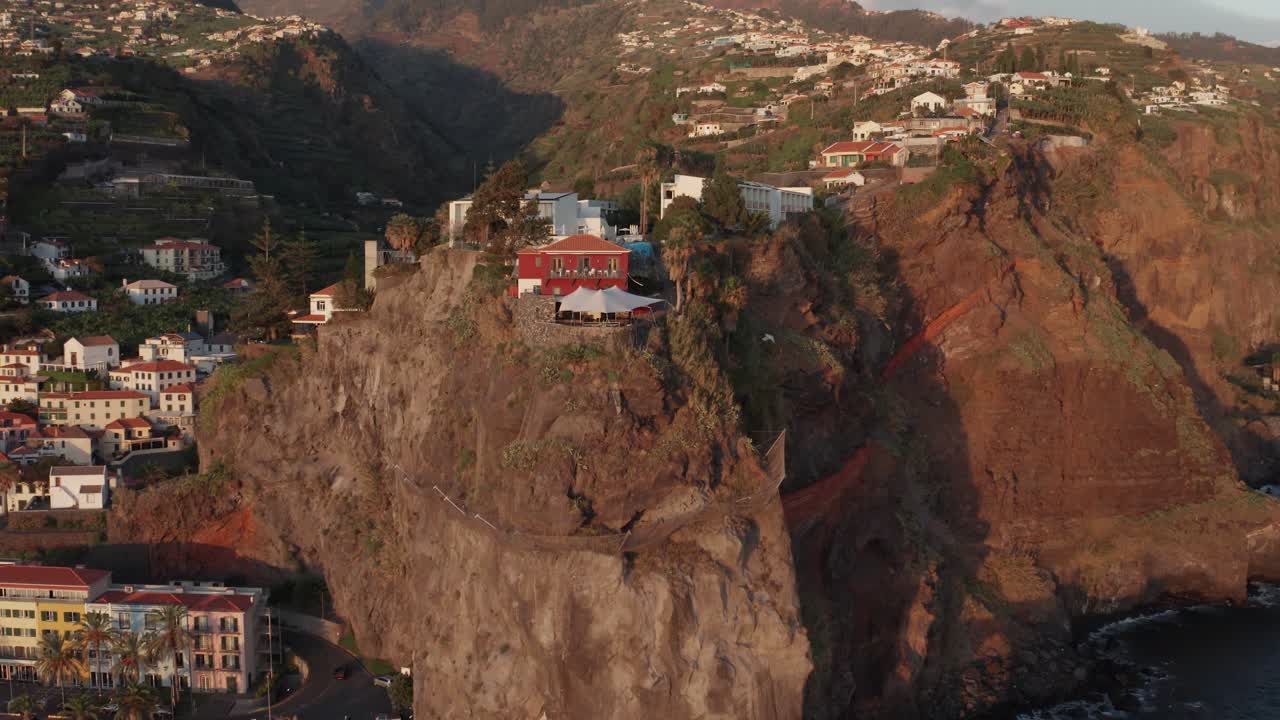 ciudad costera pintoresca con edificios en la cima de una cordillera y en el valle durante la puesta de sol en ponta do sol, madeira, portugal