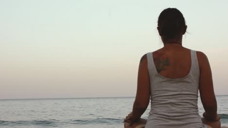 girl meditating at the beach