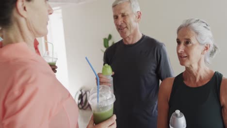 happy diverse seniors talking with female pilates coach and drinking, unaltered, in slow motion