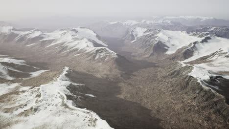 Gran-Parche-De-Nieve-Que-Quedó-En-El-Campo-De-Roca-Volcánica-De-Una-Montaña-En-Verano