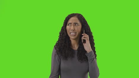 frustrated woman talking on mobile phone against green screen before hanging up 1