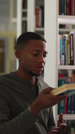 el lector toma libros del bibliotecario por las estanterías. el estudiante afroamericano obtiene literatura para el ensayo con la ayuda de un amigo en el almacenamiento de la universidad. fuentes de educación