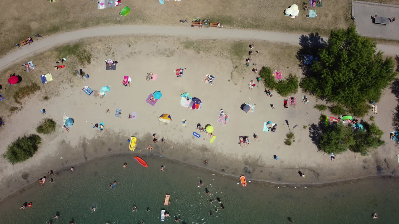 Aerial View of a Crowded Beach and Lake on a Sunny Day