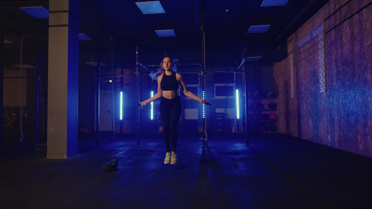 Slow motion: young woman skipping rope. woman jump roping in the gym as ...