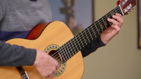 close-up shot of a man playing scales on a classical guitar