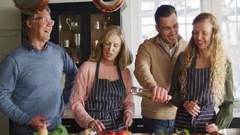 video von glücklichen kaukasischen älteren mutter und vater kochen mit erwachsenen tochter und ehemann in der küche