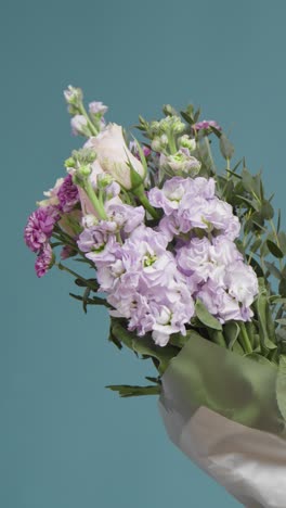 Vertical-Shot-of-a-Man-Holding-Flowers