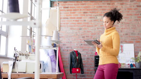 Nachdenkliche,-Glückliche-Biracial-Modedesignerin-Mit-Tablet-Im-Studio,-Kopierraum,-Zeitlupe