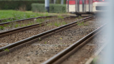 Las-Vías-Del-Tren-Convergen-En-La-Distancia-Con-Un-Tren-Borroso-Acercándose,-Sugiriendo-Movimiento-Y-Viaje.