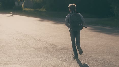 Junger-Mann-Mit-Ungebundenen-Schnürsenkeln-Läuft-Die-Graue-Asphaltstraße-Entlang