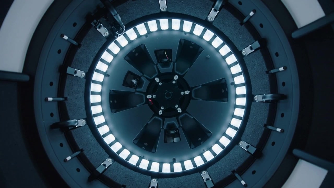 Strumento guantato che interviene per regolare l'orientamento di un rotore circolare in una camera di prova di laboratorio, con morsetti ad anello LED.