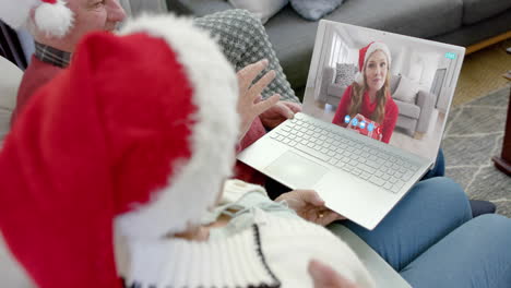 happy caucasian senior parents and daughter having christmas laptop video call, slow motion