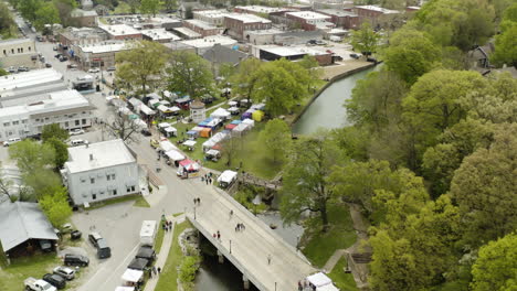 AERIAL---Sager-Creek,-Dogwood-Festival,-Siloam-Springs,-AR,-rising-tilt-down