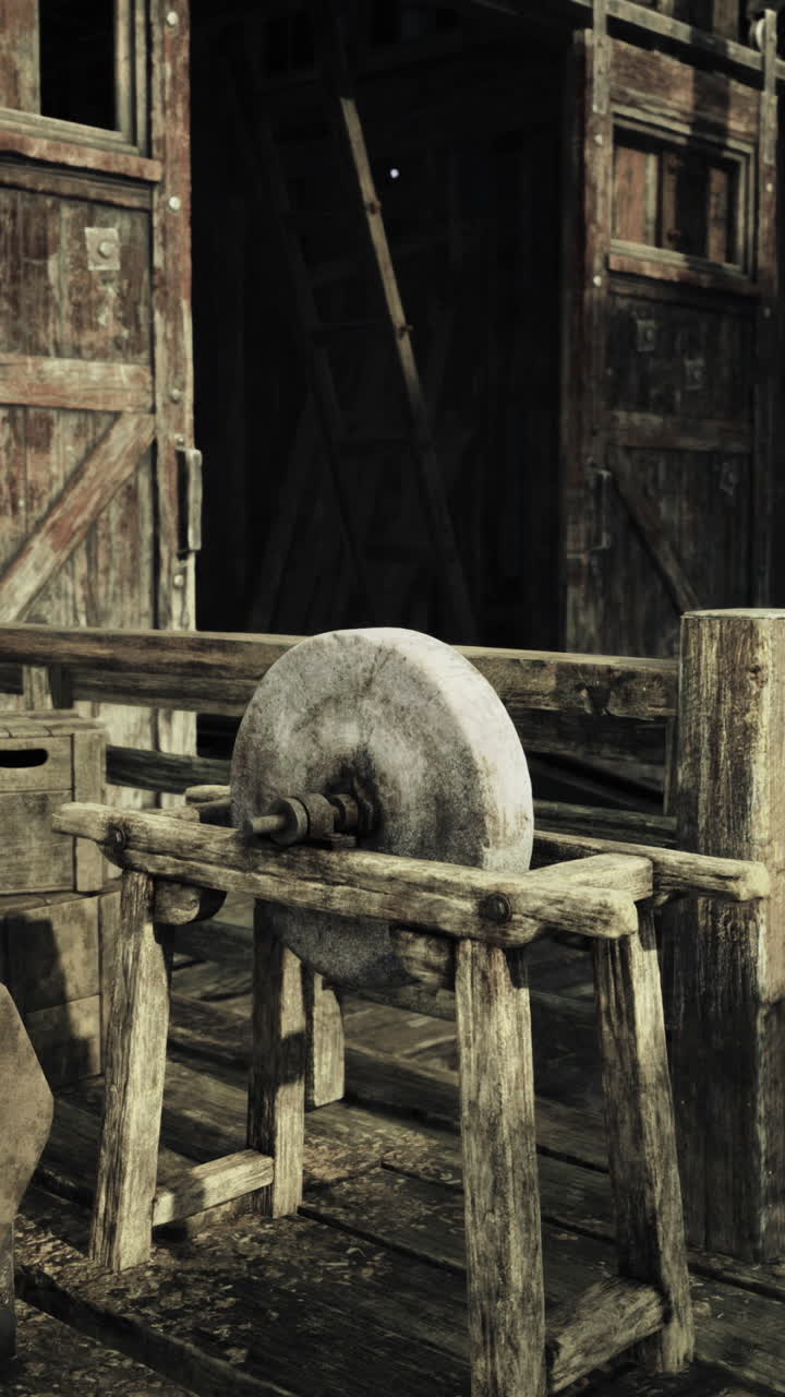 Wooden structure with a round object in a rustic setting during the day