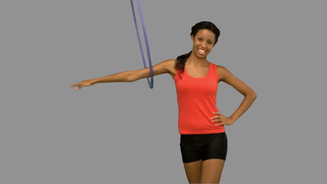 Woman-working-out-with-a-hula-hoop-on-grey-screen